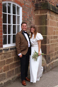a bride and groom posing in front of a brick building