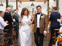 a bride and groom walking down the aisle at a wedding