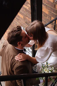 a bride and groom kissing on a balcony