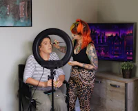a woman is getting her makeup done in front of a tv