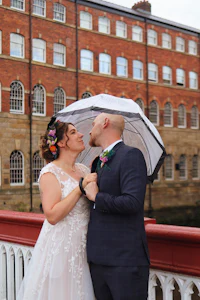 a bride and groom kissing under an umbrella