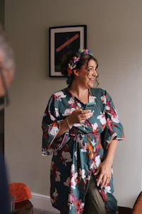 a woman in a floral kimono is talking to a man in a room