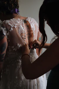 a woman putting on a wedding dress