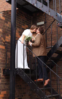 a bride and groom kissing on a staircase