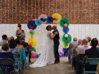 a bride and groom kiss in front of colorful paper lanterns