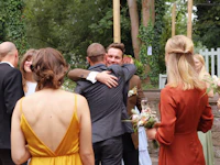 a group of people hugging at a wedding