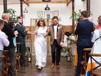 a bride and groom walking down the aisle at a wedding