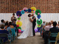a bride and groom kiss in front of colorful paper lanterns
