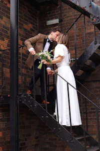 a bride and groom kissing on a staircase