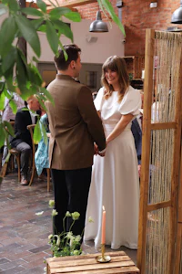 a bride and groom standing in front of a wooden table