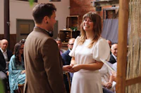 a bride and groom smiling at each other during their wedding ceremony
