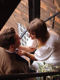 a man is adjusting a woman's tie
