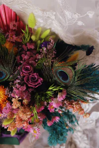 a bouquet of colorful flowers with peacock feathers