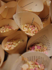 a bunch of paper cups filled with rose petals