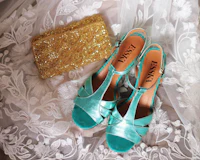 a pair of turquoise wedding shoes and a gold clutch