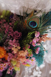 a bouquet of colorful flowers with peacock feathers