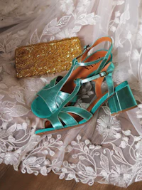 a pair of shoes and a clutch on a white lace dress