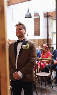 a man in a tuxedo standing in front of a crowd